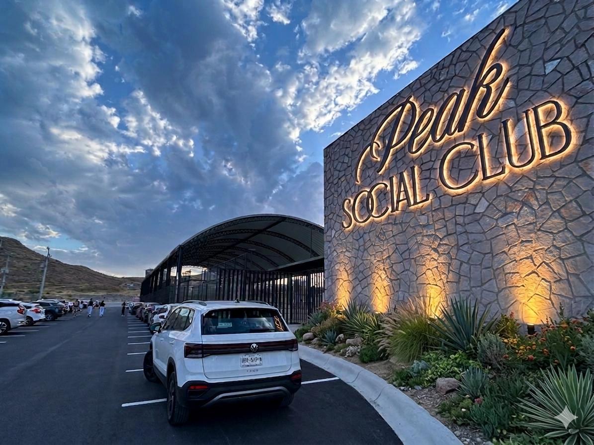 Acceso iluminado del Peak Social Club al atardecer
